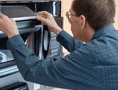 Appliance repair technician replacing a microwave vent filter in Anaheim, CA