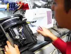 Vacuum repair technician servicing internal components on a workbench in Anaheim, CA